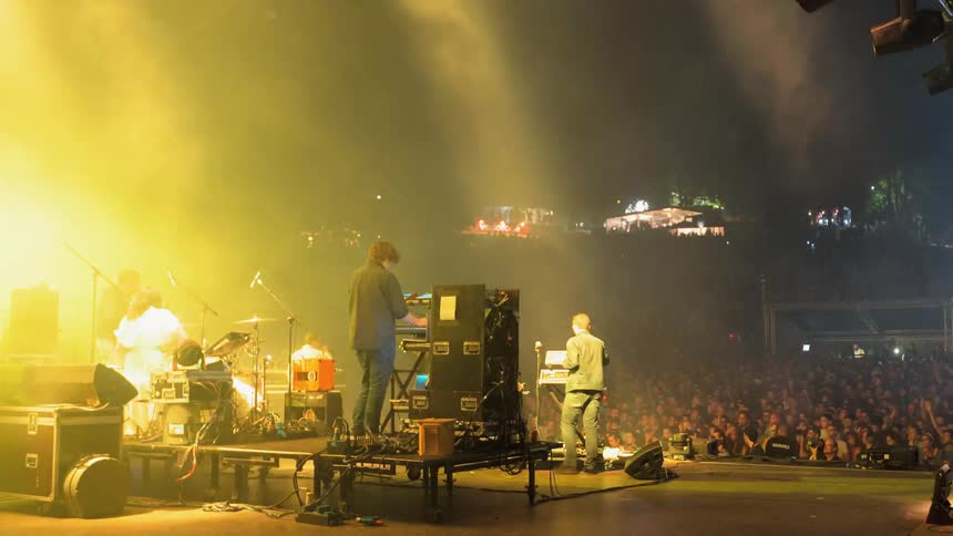 Band plays on stage at a concert with lights flashing