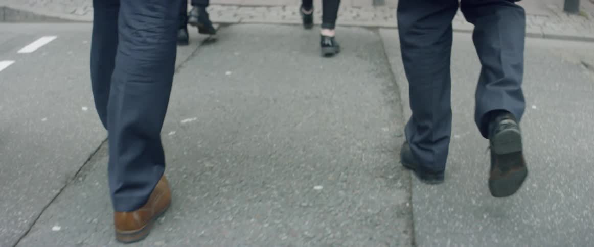 People are walking on a sidewalk in a city during the day