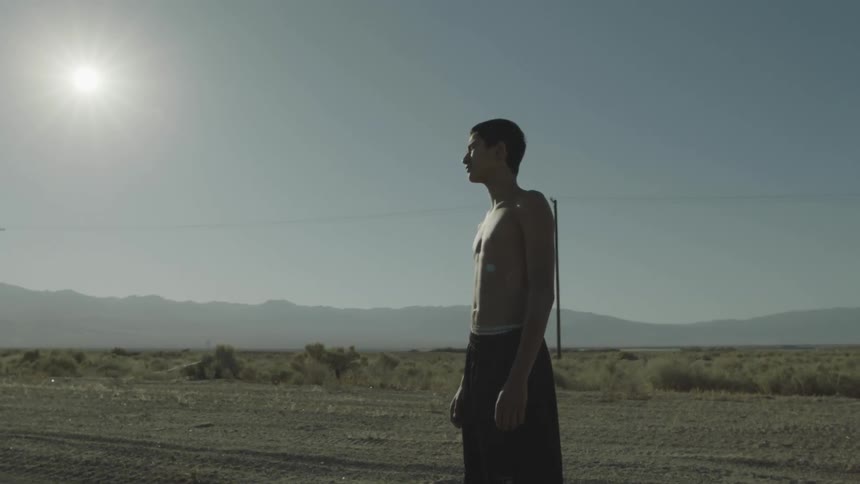 Man stands outside on a road shirtless