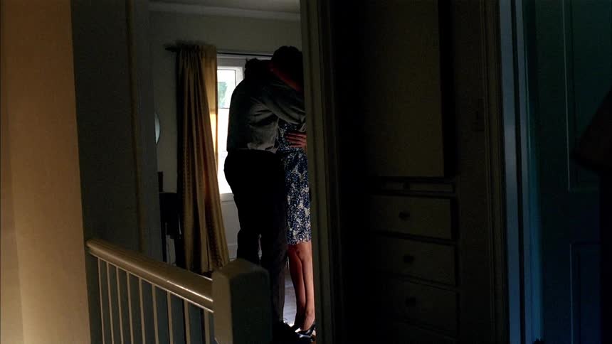 A couple embrace inside a home during the day