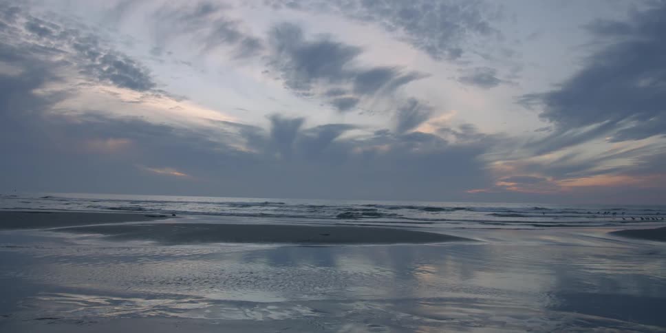 Ocean waves wash ashore at sunset
