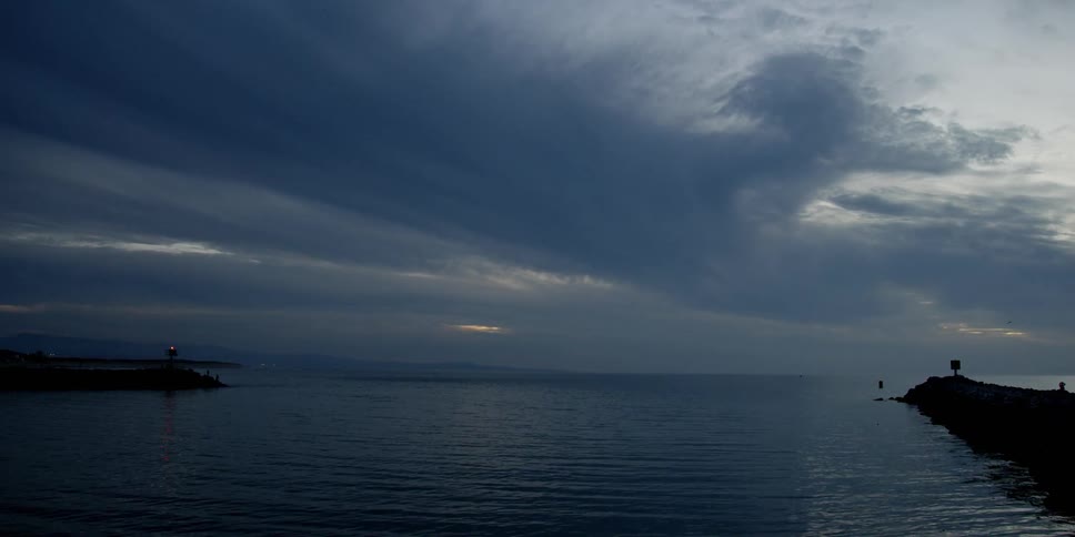 Clouds are drifting over a jetty at dusk
