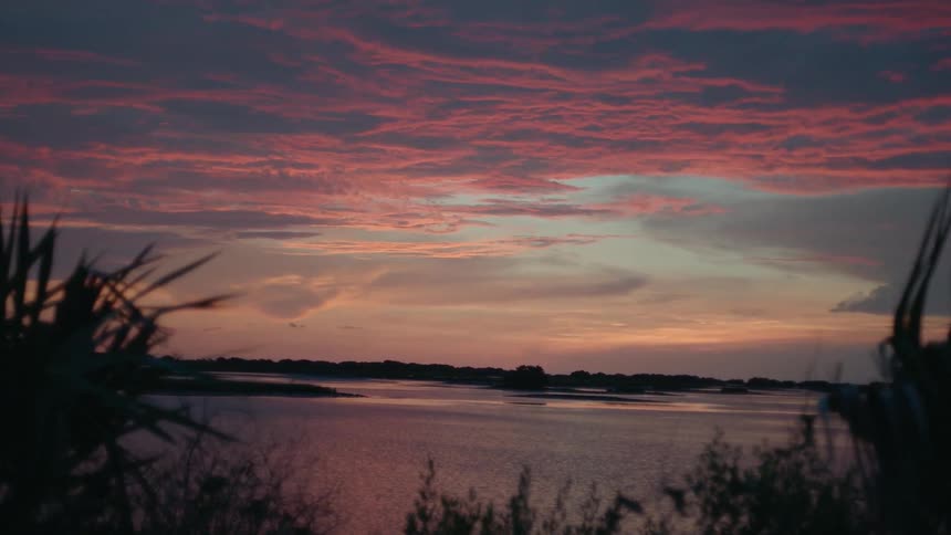 Clouds float over a lake at sunset