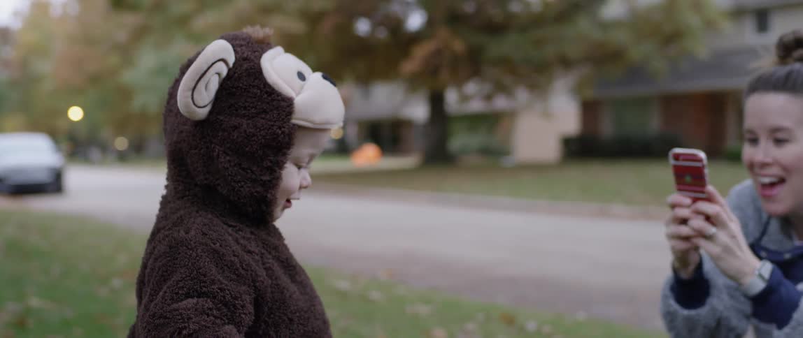 A mom photographs her toddler in a monkey costume