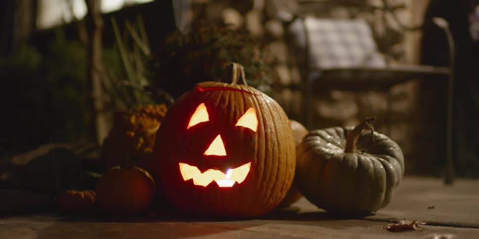 A candle burns inside a carved pumpkin