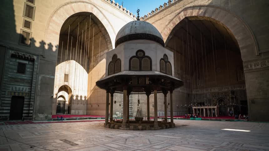 People walk through an ornate courtyard