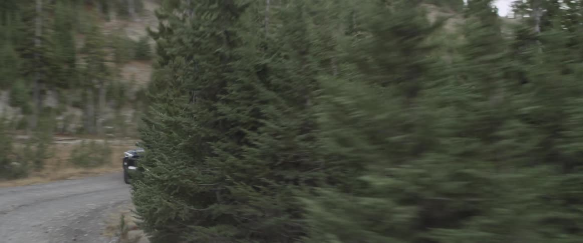 An suv drives on a curving dirt road