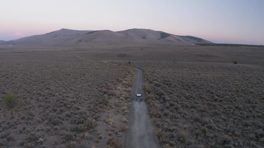 Jeep drives on a country road surrounded by plains
