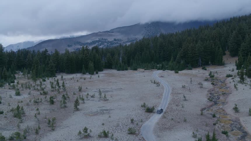 A vehicle drives on a mountain road
