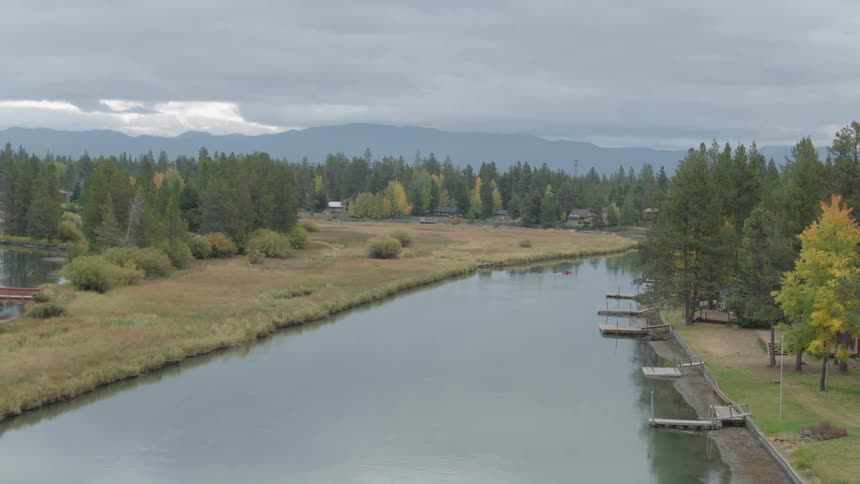 Clouds float over a river and forest trees