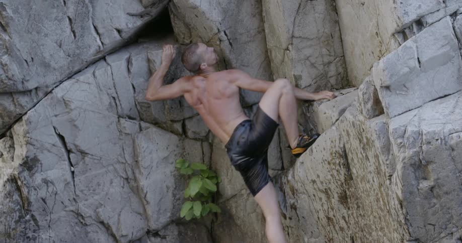 Man climbs up a rocky cliff