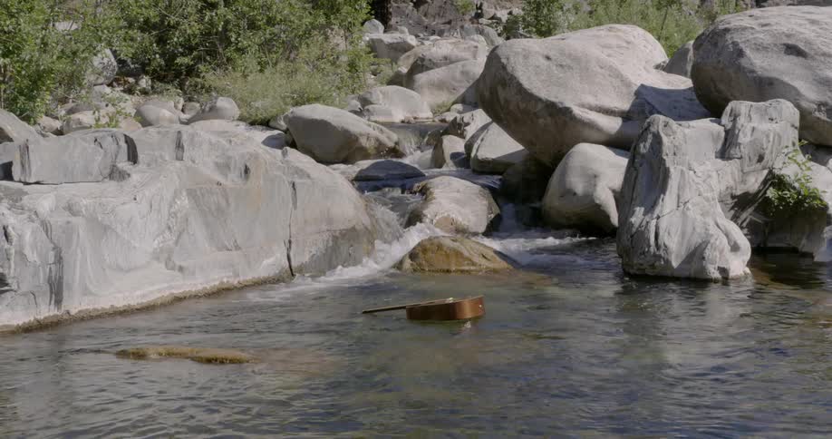 A guitar floats down a flowing river