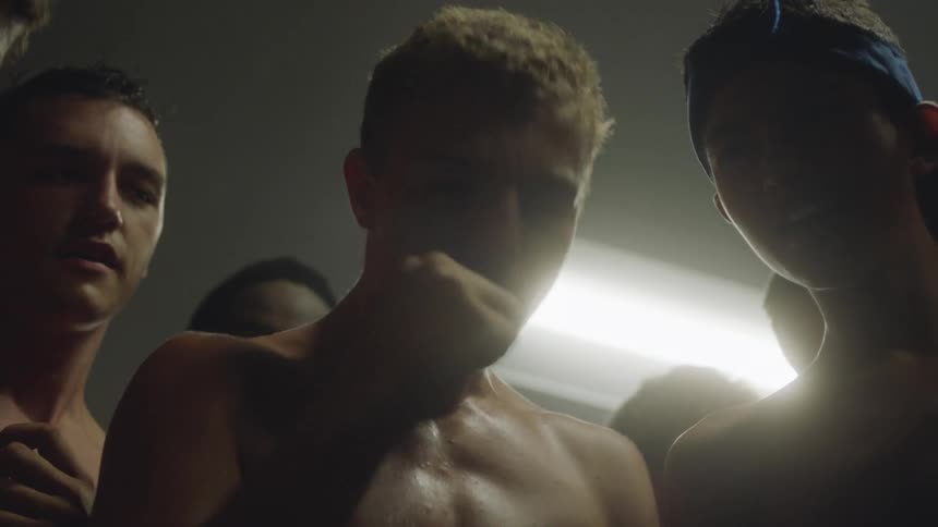 Shirtless men gathered in a circle