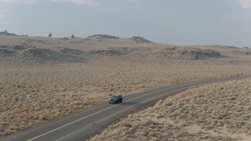 An suv drives on a rural road on a sunny day