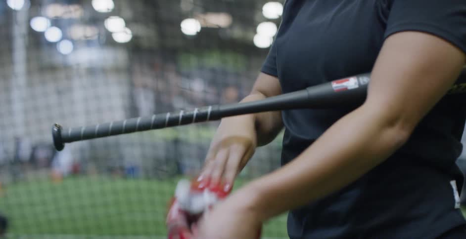 Woman takes gloves off an throws down baseball bat