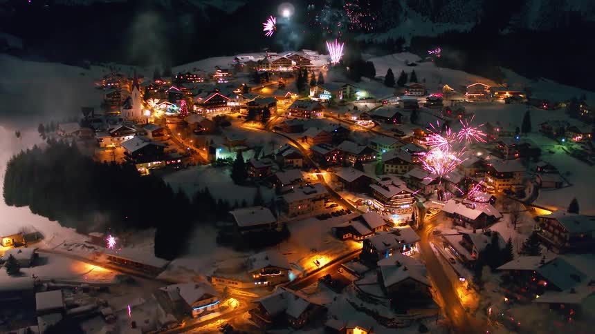 Fireworks exploding all over a small town on a festive evening