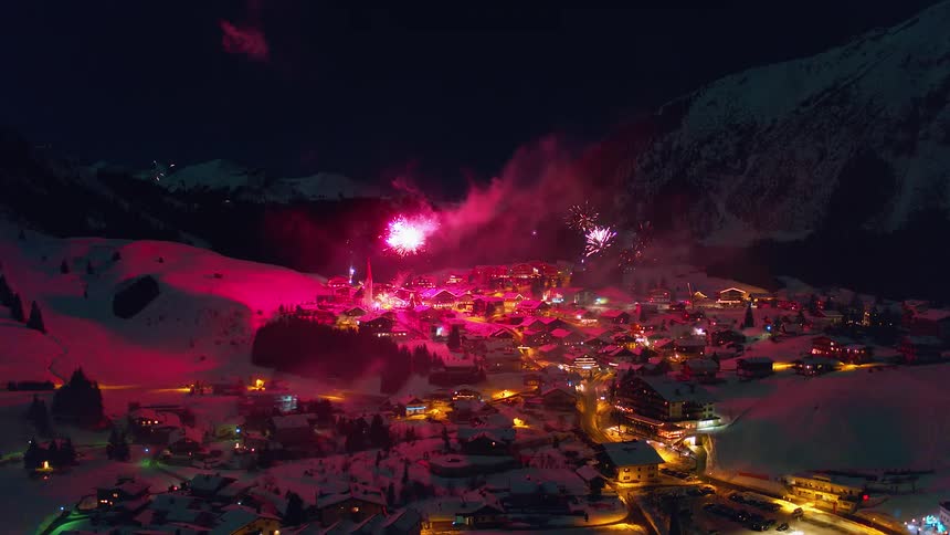 Fireworks explode above a snowy village