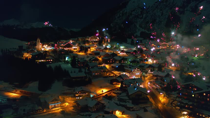 Fireworks explode above a snowy village