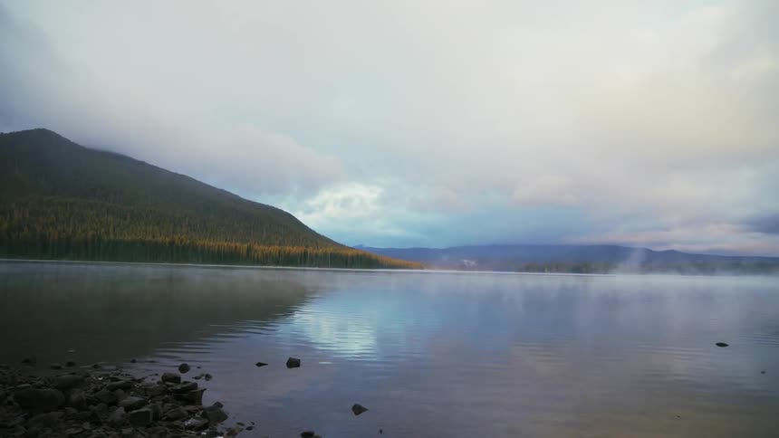 Water flows in a lake by a large hill