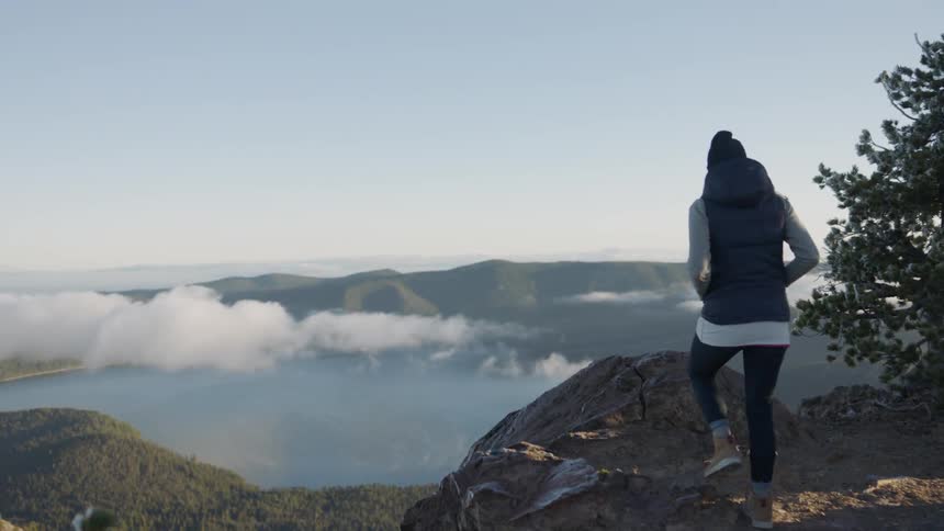 A hiker walks towards a cliff edge