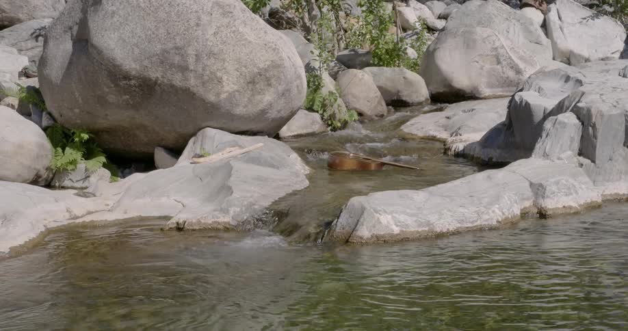 A guitar flowing among the rocks down a stream