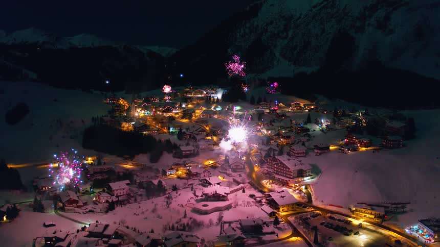 Fireworks exploding all over a small town on a festive evening