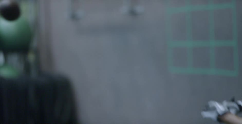 A man catches a football thrown by a jugs machine