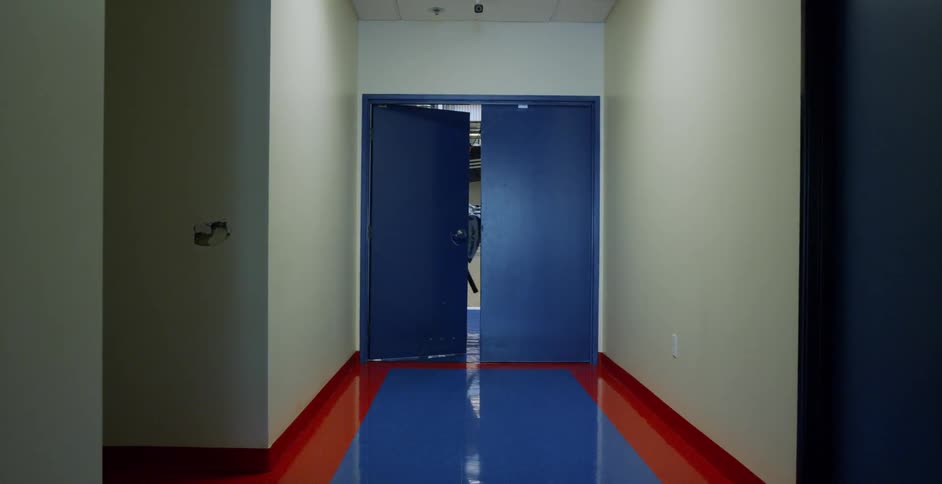 An athlete walks through double doors into the gymnasium