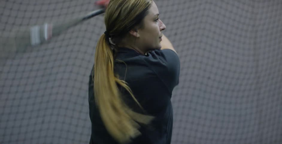 Woman swings a bat near a net