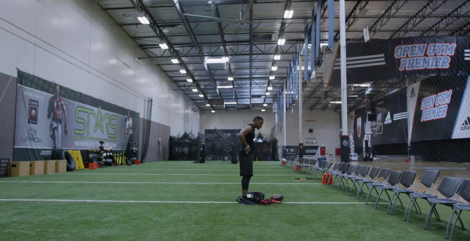 An athlete drops his gear in an indoor training facility