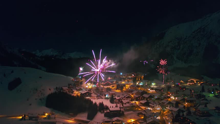 Fireworks explode over a snow covered village