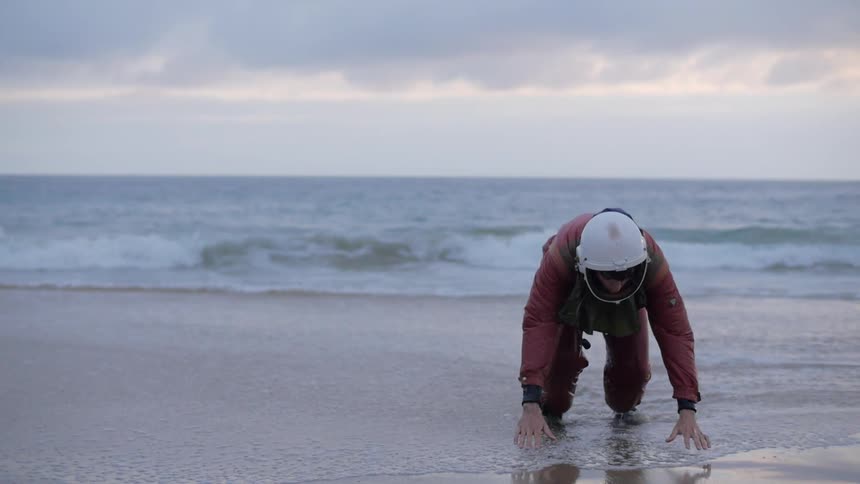 Man walks from the water wearing helmet