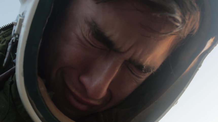 Man wearing helmet beings to cry