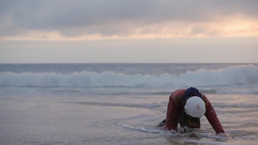 A person kneeling in water