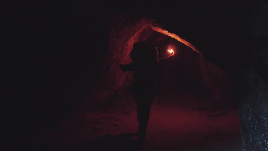 A person walking into a cave