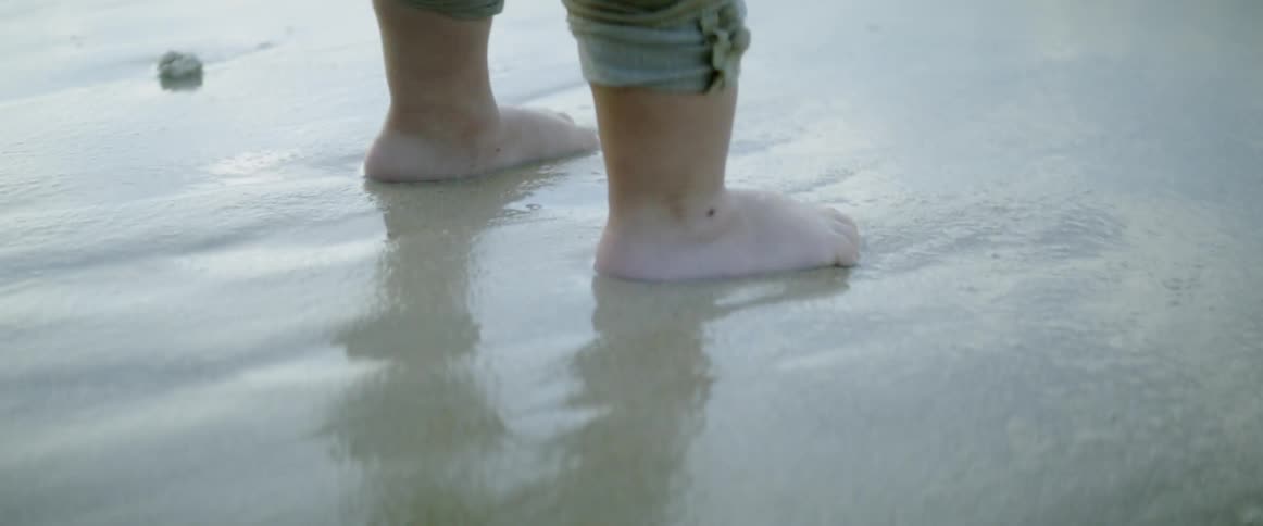 Toddle stands by ocean's edge