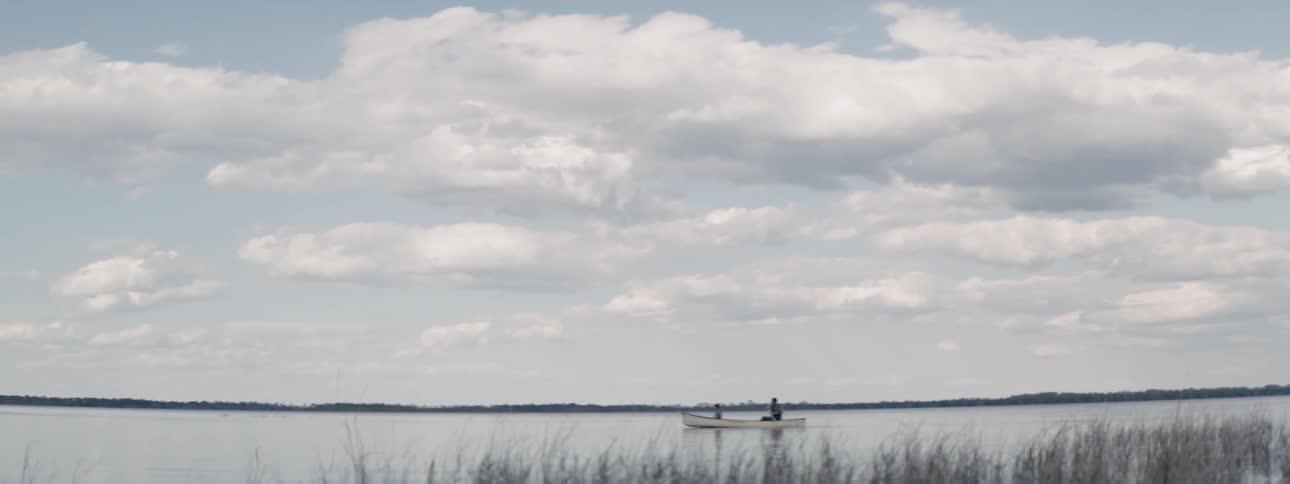 A person rows a boat through the water