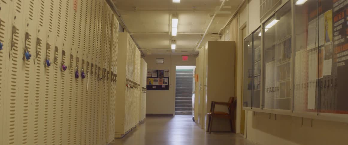 Hallway with lockers lining it and stairs at the end