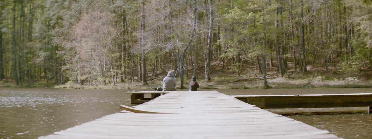 Man and boy fish off a dock