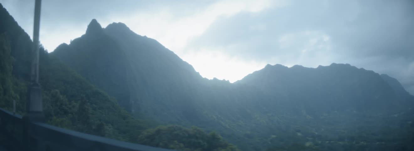 Clouds hang above tall mountains