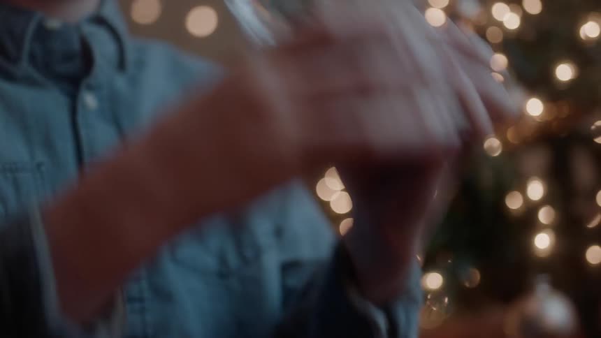 A boy picks up and shakes a snow globe