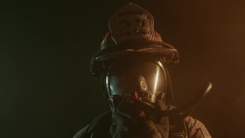 Firefighter attaches oxygen to face mask