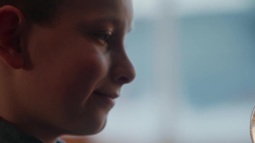 Boy gazes at a snow globe