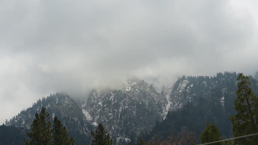 Snow covered mountain tops covered in thick clouds