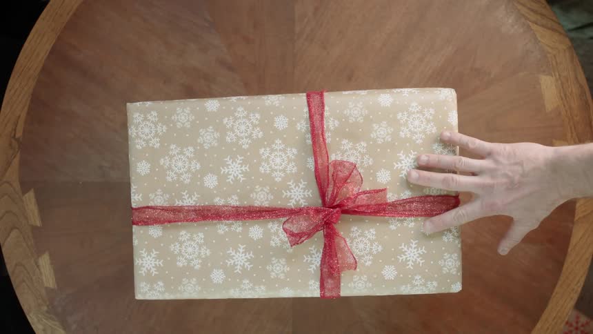 A christmas gift is exchanged over a table