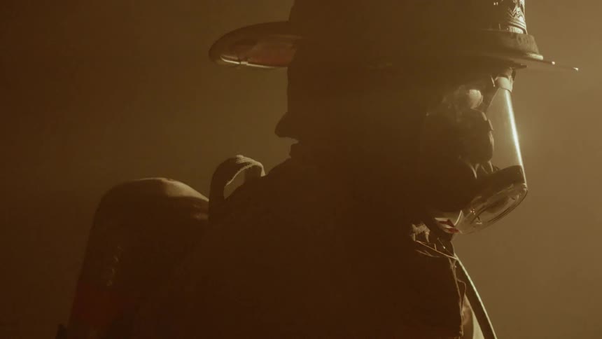 A firefighter wears a mask in a smoky area