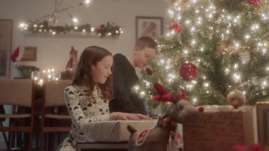 Girl and boy run to see presents on christmas morning