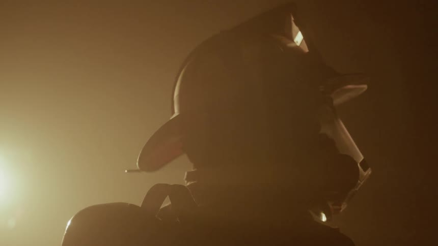Firefighter stands gazing at a fire