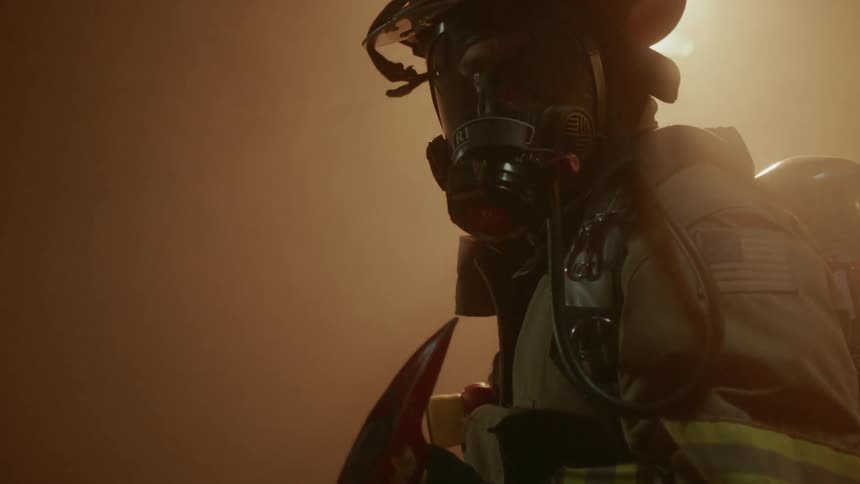 Firefighter lifts axe and turns
