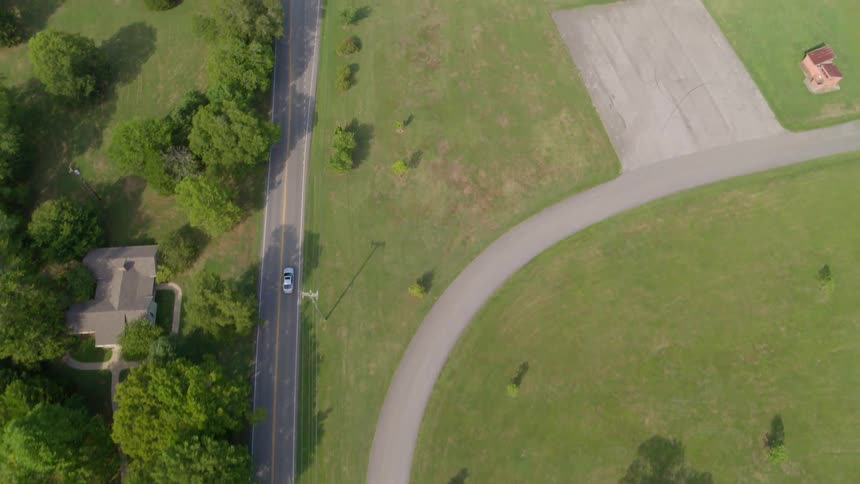 Cars drives down a highway running past fields
